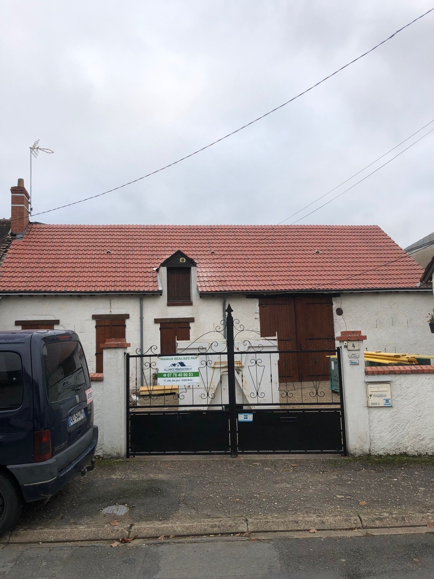 Façade d'une maison avec pancarte publicitaire sur le portail