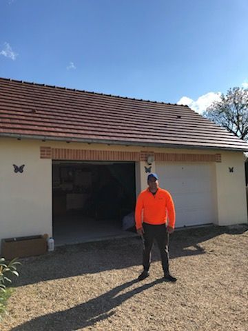 Employé se tenant devant une maison dont le toit a été nettoyer