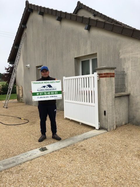 Employé de l'entreprise devant une maison tenant une pancarte publicitaire