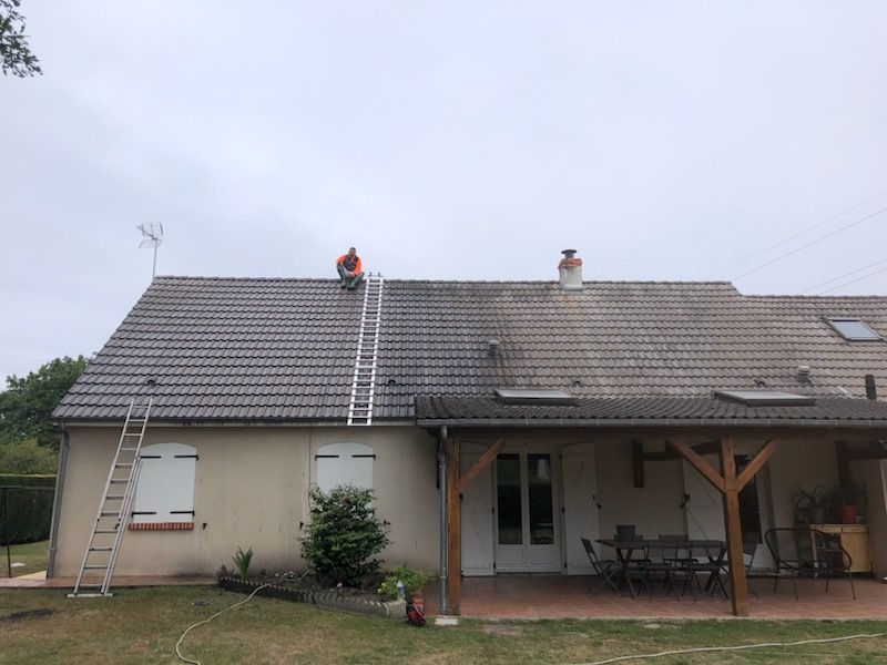 Façade d'une maison avec toiture en cours de démoussage