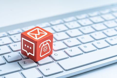 Cube rouge représentant une icône d'e-mail sur un clavier d'ordinateur, avec des symboles de courrier et de message.