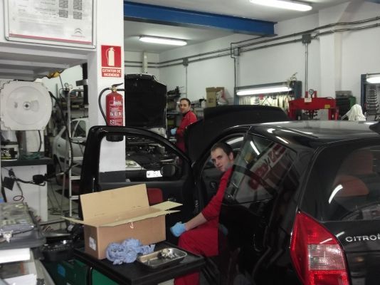 Un hombre está trabajando en un coche en un garaje.