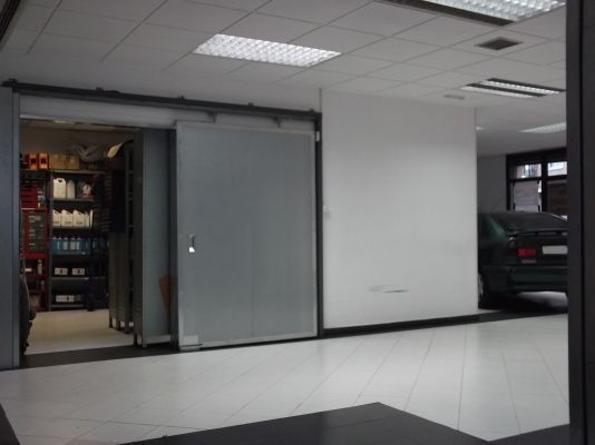 Un coche está aparcado en un garaje al lado de una puerta corredera.