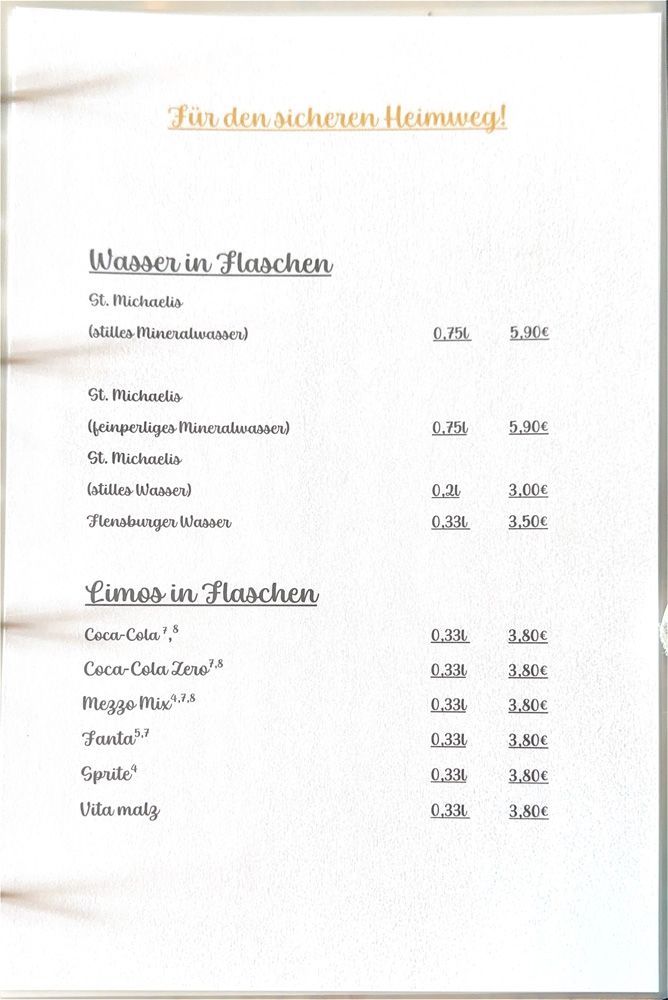 Verschwommene deutsche Speisekarte auf weißem Papier, auf der Speisen und Getränke in Abschnitten aufgelistet sind.