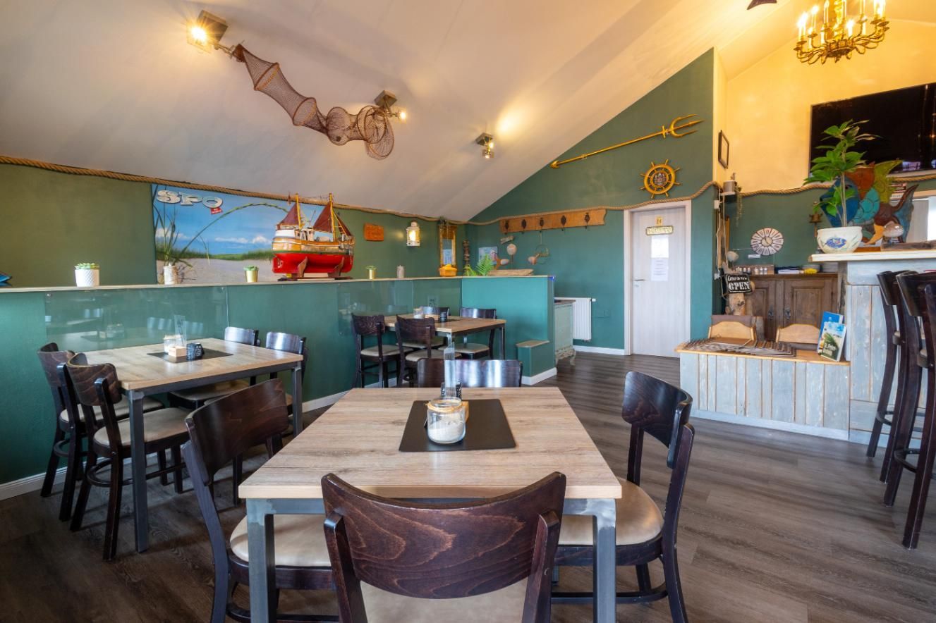 Ein Fischrestaurant mit Tischen und Stühlen und einer gewölbten Decke.