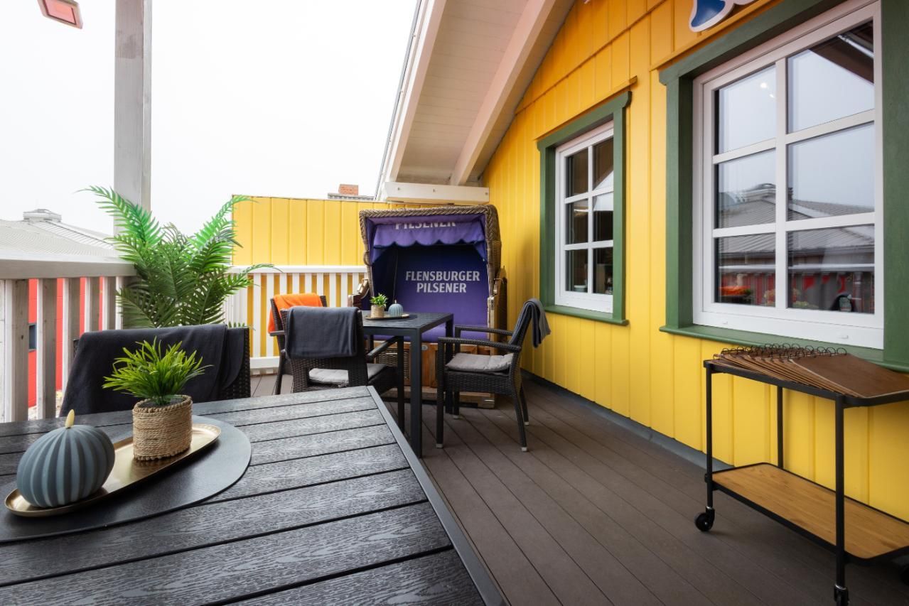 Auf dem Balkon eines Fischrestaurants stehen ein Tisch und Stühle.