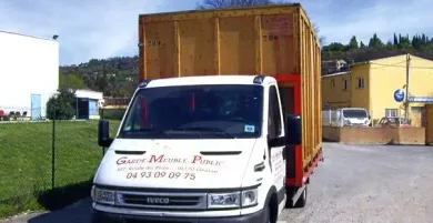 Camion de déménagement blanc avec un conteneur de fret jaune ; stationné à l'extérieur.