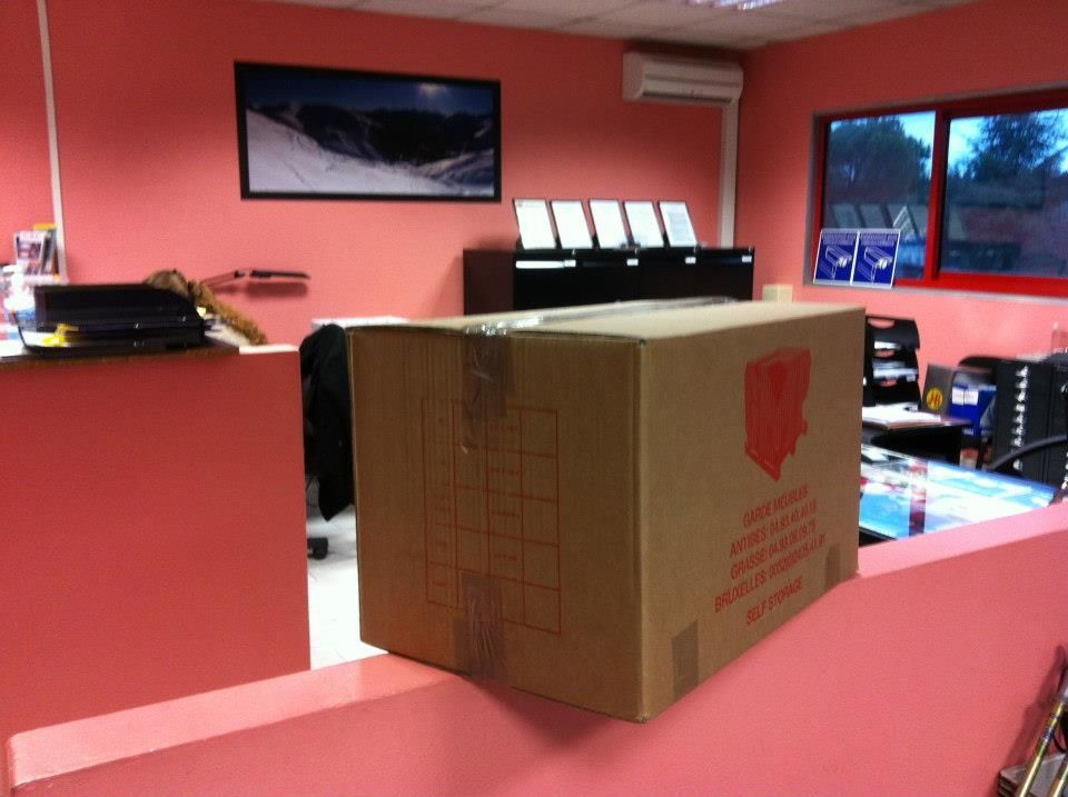 Boîte en carton posée sur un comptoir rose dans un bureau.