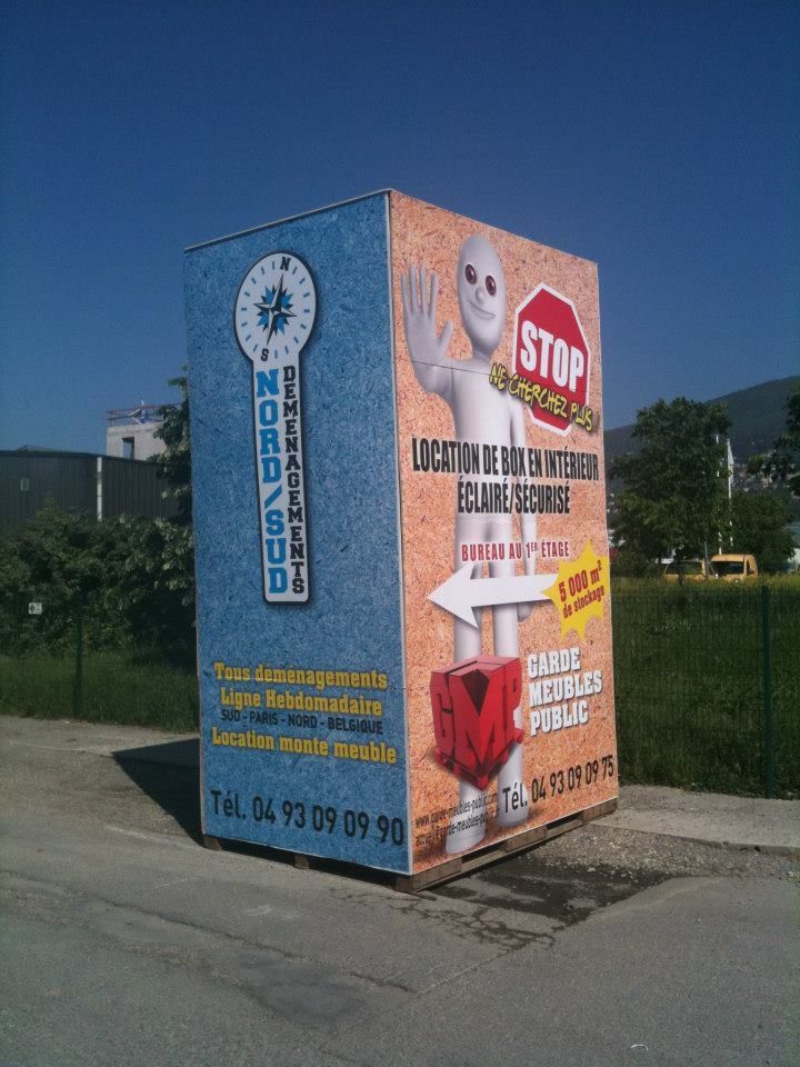 Panneau d'affichage : « Nord/Sud » avec boussole, silhouette extraterrestre faisant signe « stop ».