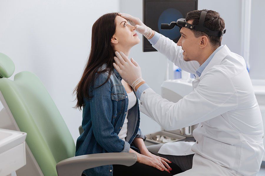 HNO Arzt untersucht den Hals einer Patientin