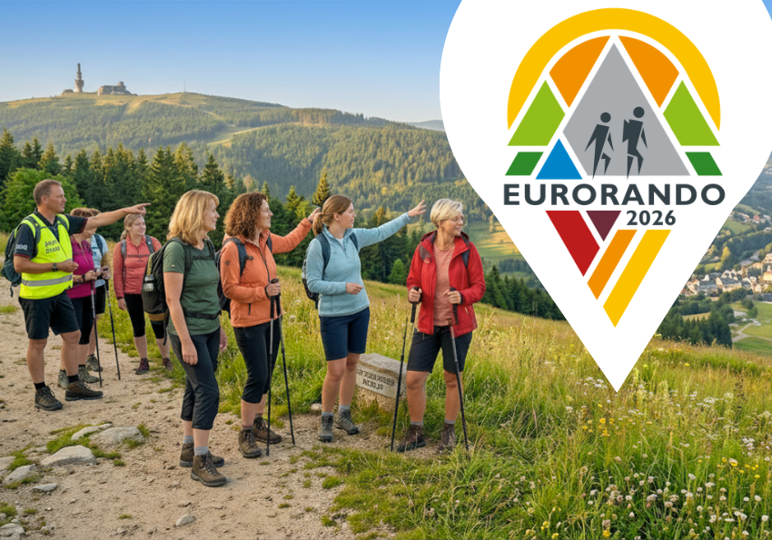 Wanderer auf einem Bergpfad mit dem EORANDO 2026-Logo über einem malerischen Hügel und Tal