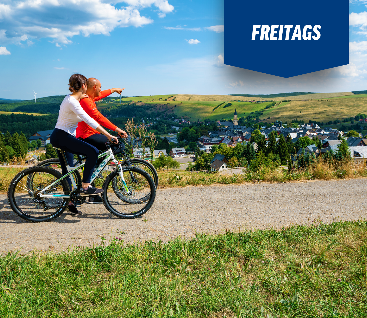 Zwei Menschen fahren mit dem Fahrrad auf einer unbefestigten Straße mit einem Schild mit der Aufschrift „Freitags“