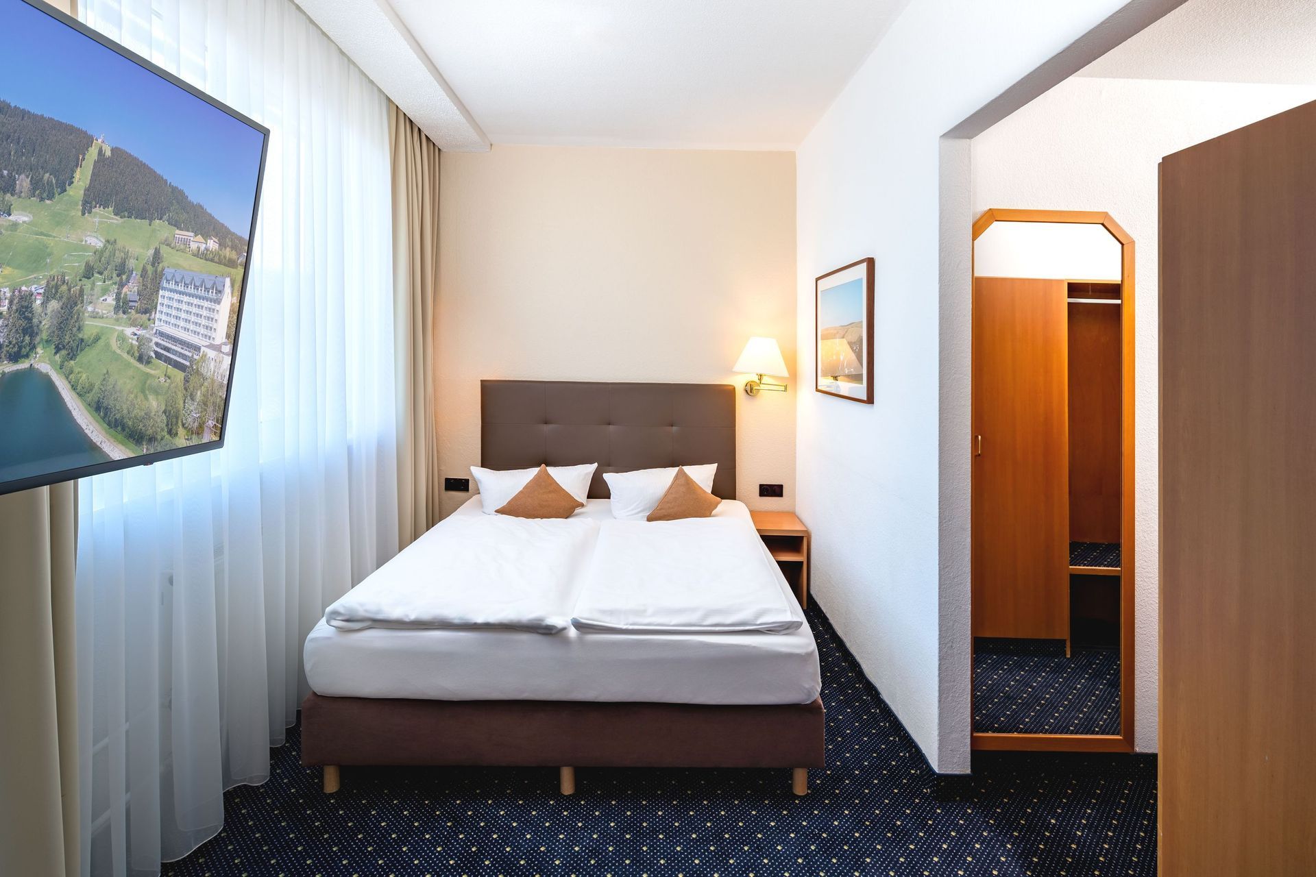 Ein Hotelzimmer mit einem Bett und einem Flachbildfernseher