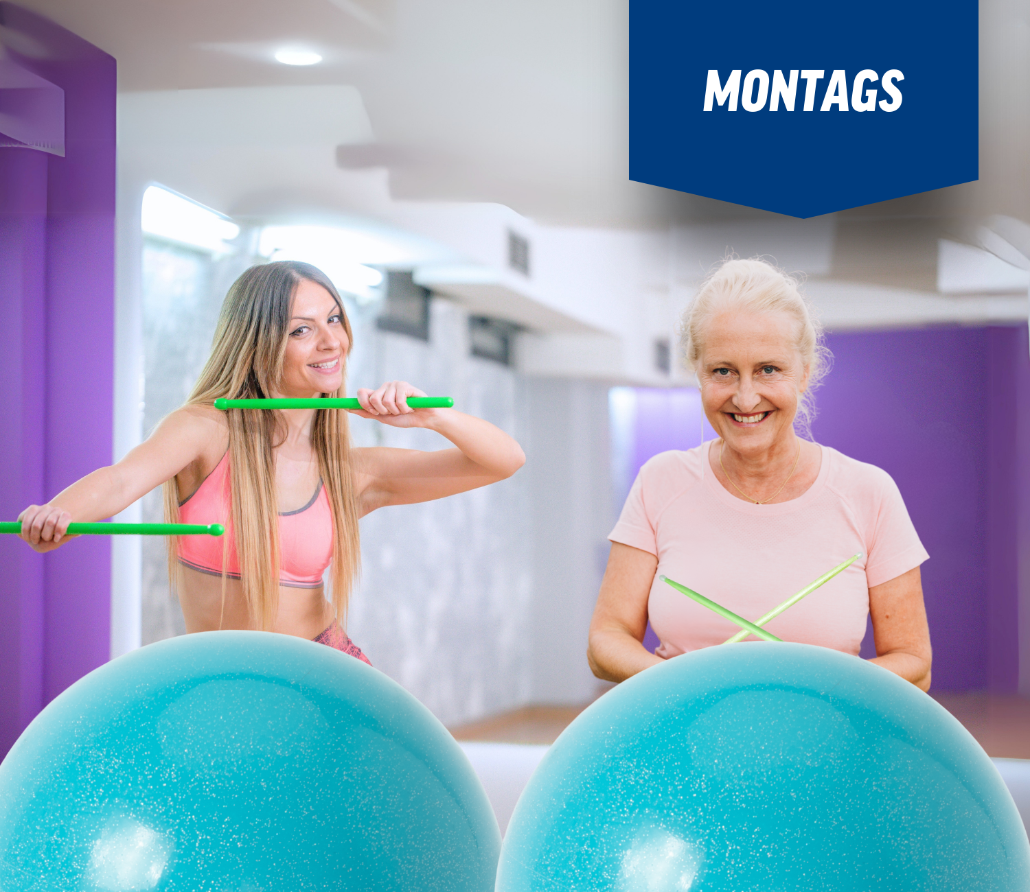 Zwei Frauen stehen nebeneinander mit Gymnastikbällen und einem Banner mit der Aufschrift Montags