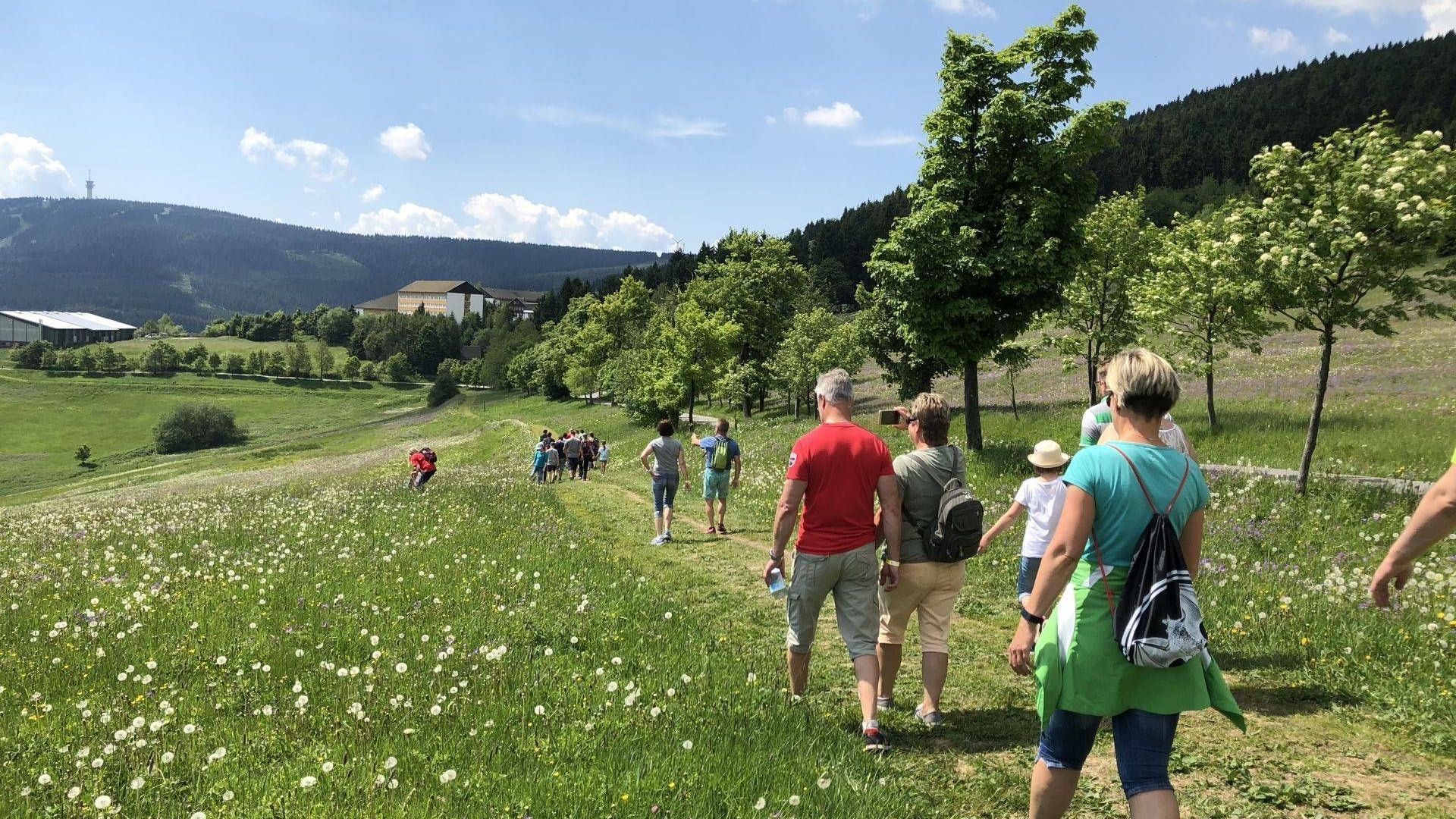 Eine Frau in einer blauen Jacke hält Skier vor einem Gebäude.