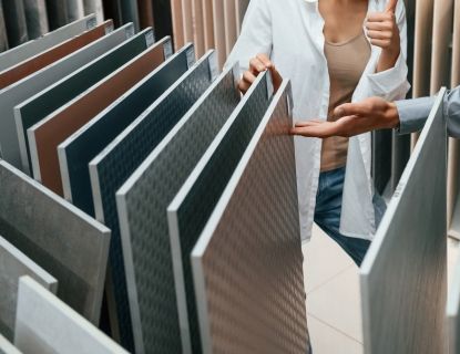 People selecting tile samples at a store, one giving a thumbs up.