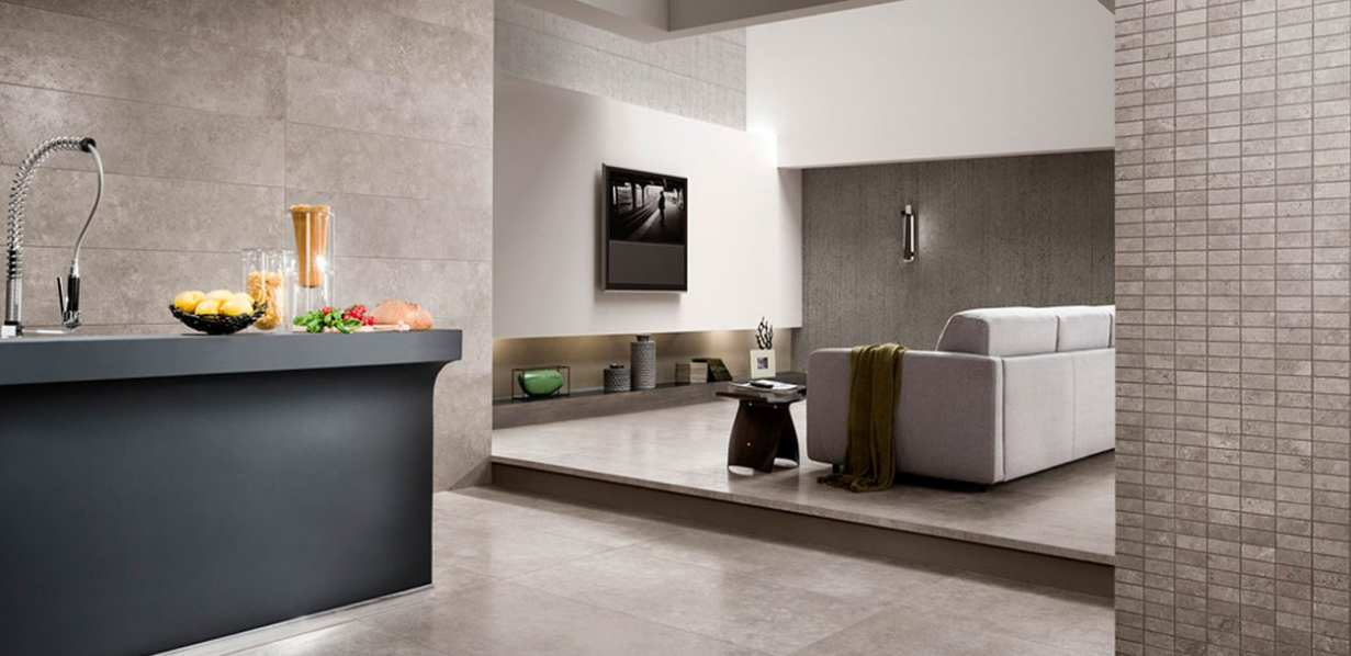 Salon et cuisine modernes à aire ouverte avec canapé gris, îlot foncé et décoration neutre
