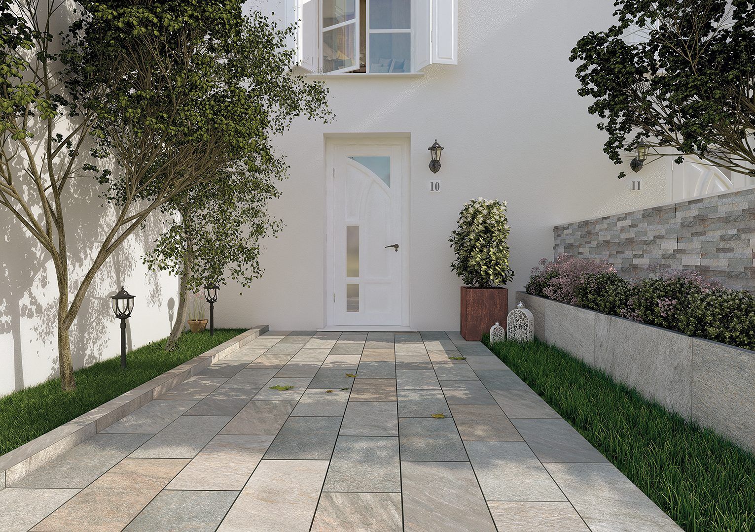 Allée d'entrée pavée menant à l'entrée d'une maison blanche, encadrée d'arbres et de murets.
