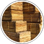 Des piles de planches de bois coupées, soigneusement empilées dans un atelier ou une scierie.