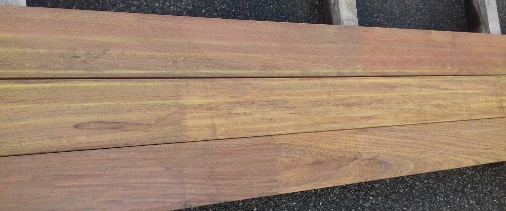 Gros plan sur deux planches de bois brun clair séparées par une ligne de grain plus foncée.