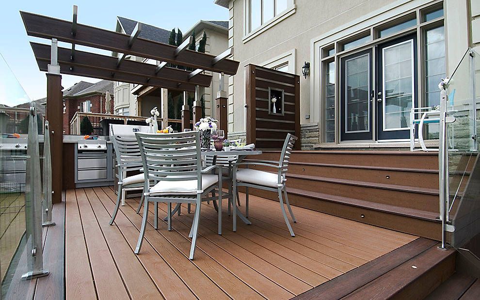 Terrasse arrière avec plancher en bois, ensemble de salle à manger d'extérieur, pergola et portes coulissantes en verre