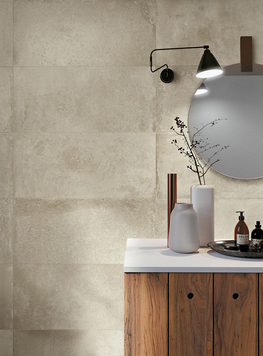Meuble-lavabo minimaliste avec armoire en bois, miroir rond, applique murale et décoration sur un comptoir blanc