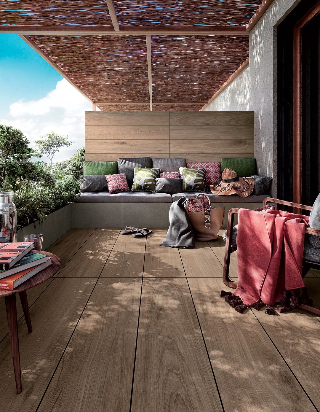 Terrasse extérieure accueillante avec sièges confortables, plancher en bois et plantes en pot sous un toit en osier