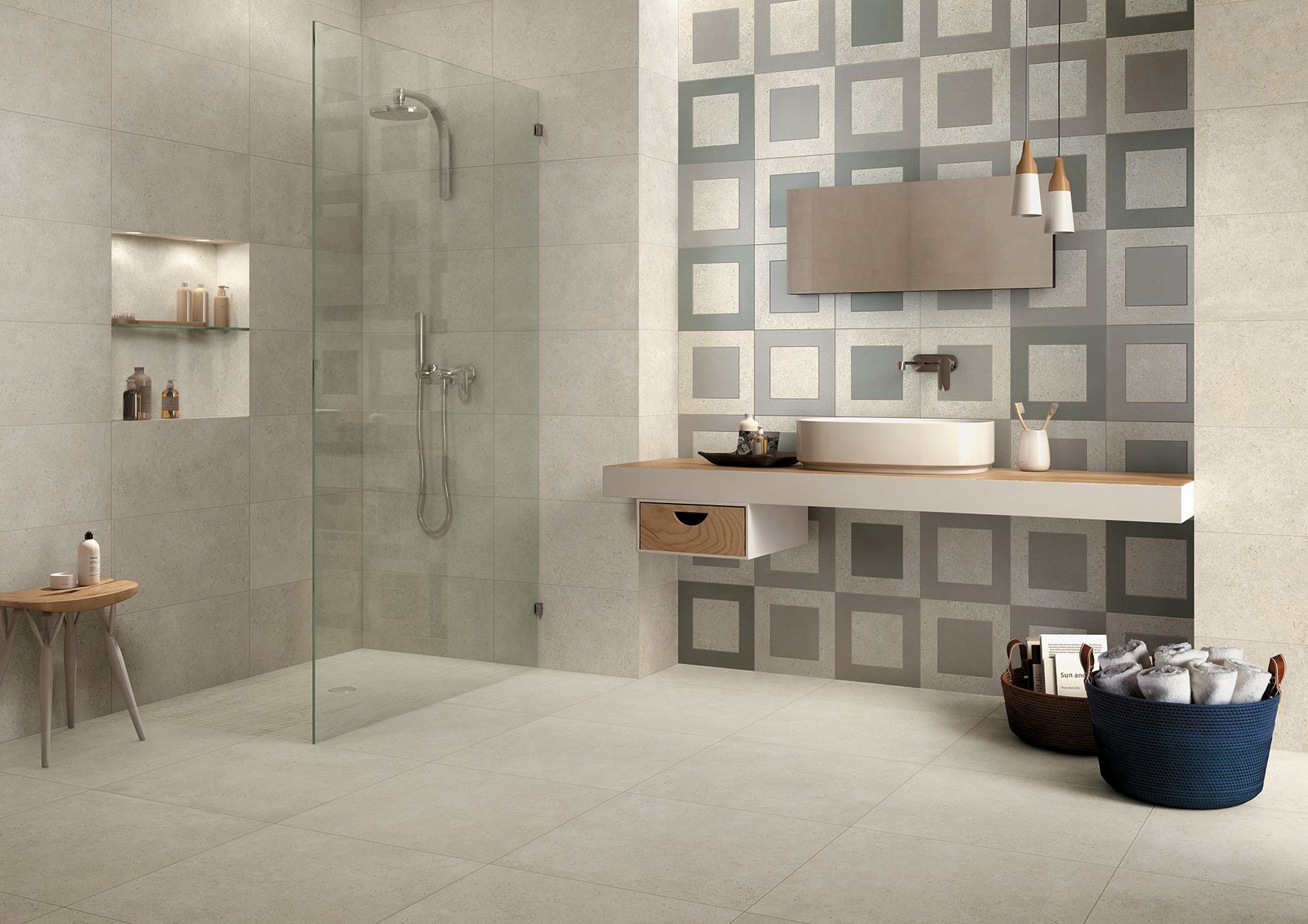 Salle de bain moderne avec douche en verre, mur carrelé à motifs, lavabo suspendu et paniers de rangement tressés