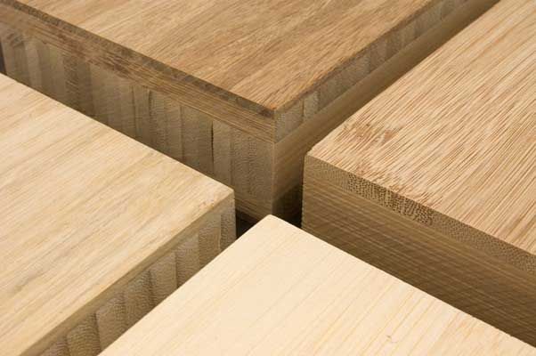 Quatre blocs de bois clair au grain visible, empilés serrés les uns contre les autres.