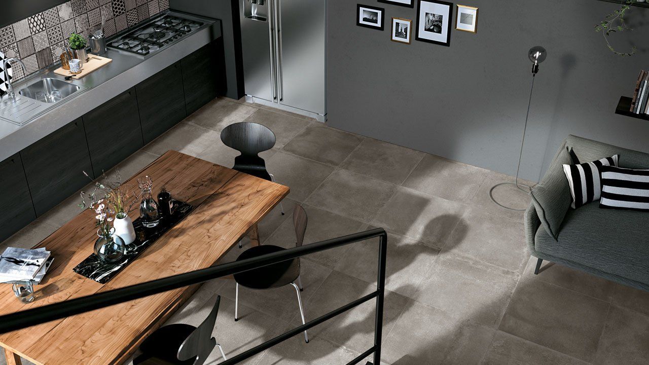 Salon moderne avec table basse en bois, canapé gris, décoration murale et sol carrelé, vu du dessus