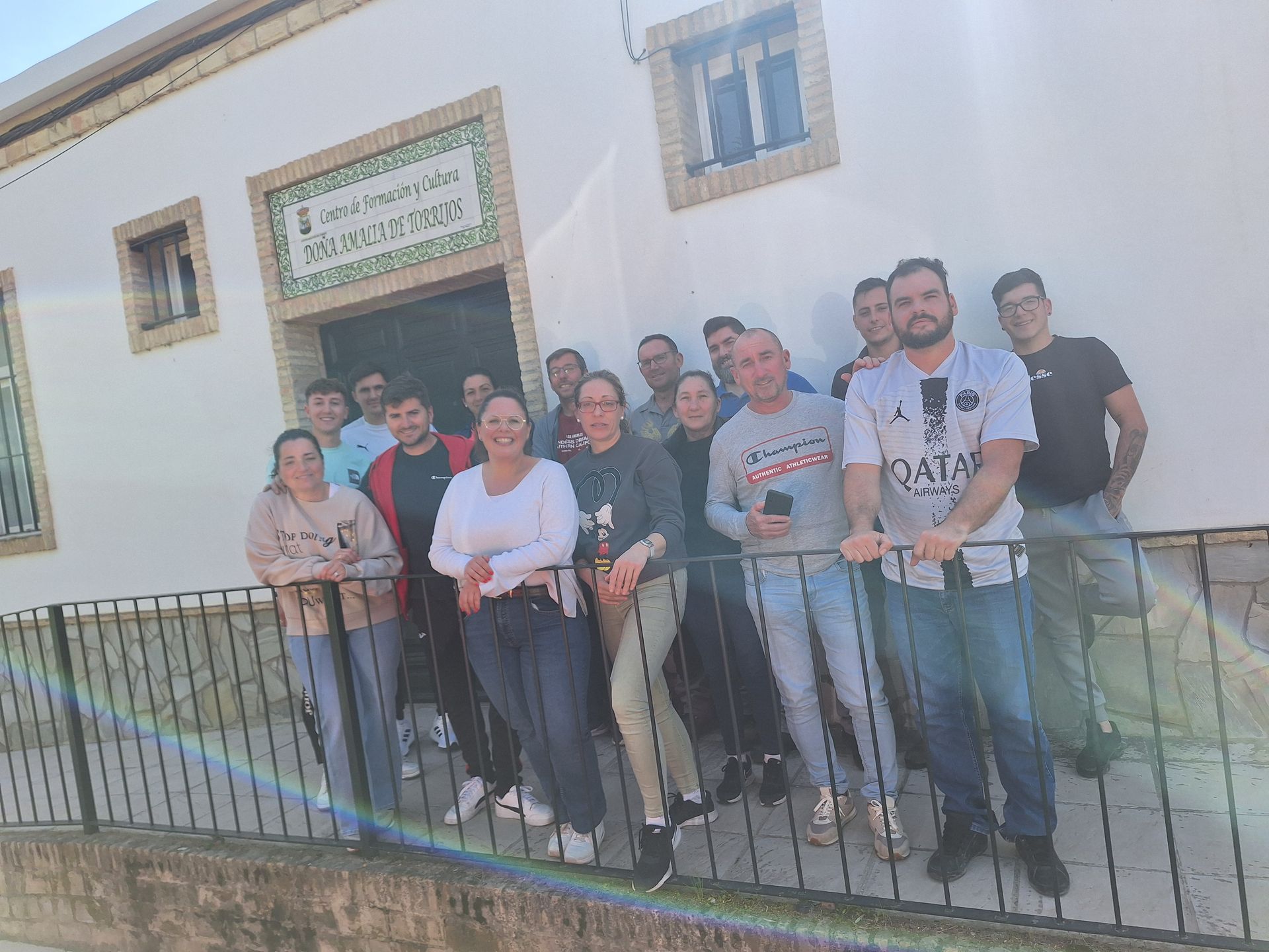 Personas colaborando en una oficina, trabajando con computadoras; la luz del sol entra por las ventanas.