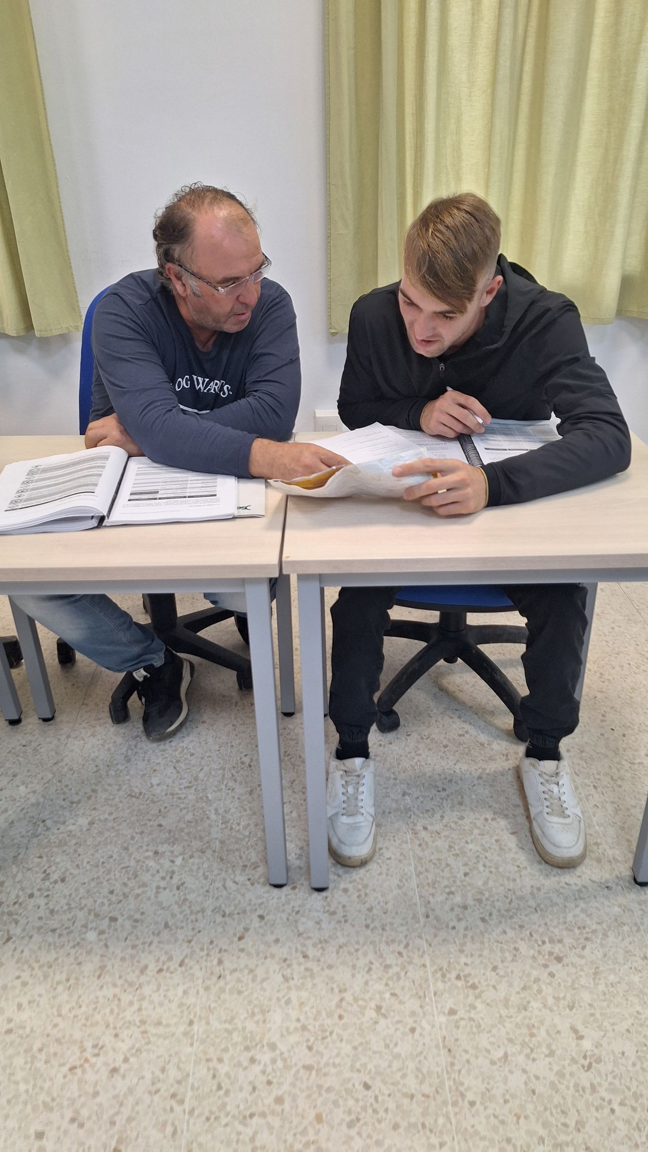 Personas en una reunión colaborativa, mirando una laptop y señalando. Oficina moderna y luminosa.