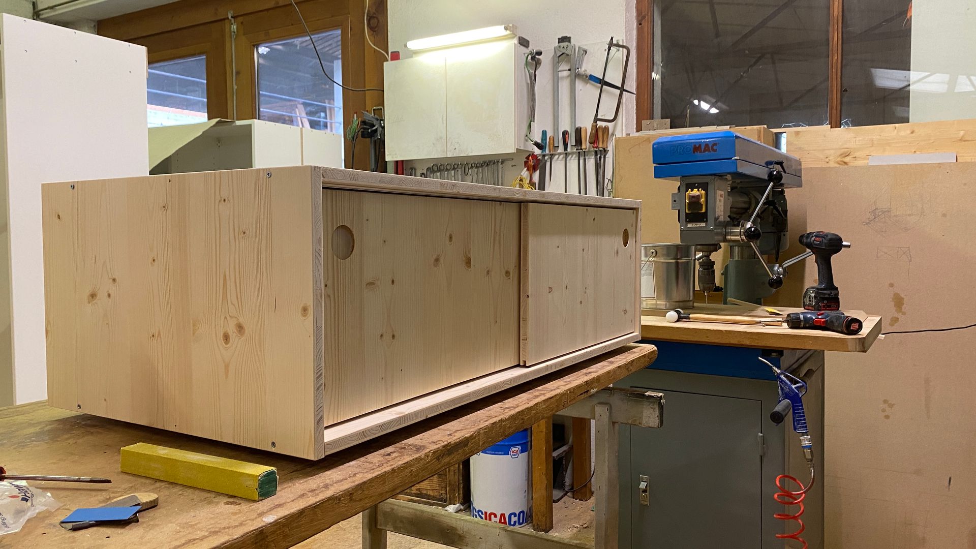 Mobiletto basso in legno di abete ad apertura scorrevole.