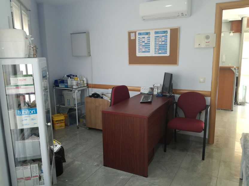 Un consultorio médico con un escritorio y sillas