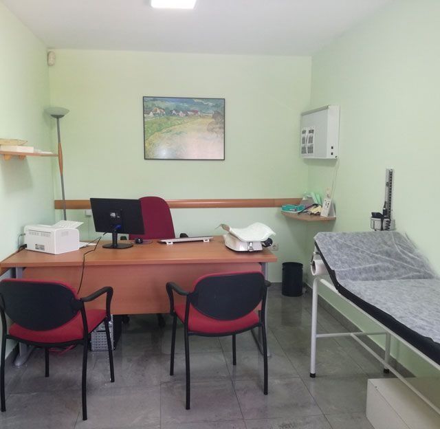 Un consultorio médico con un escritorio y sillas