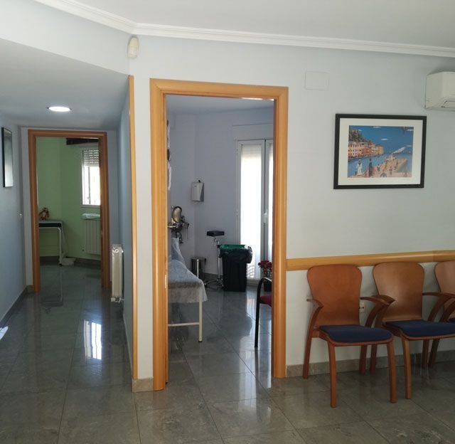 Una sala de espera con sillas y un cuadro en la pared.