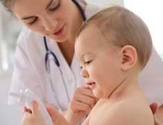 Un bebé está siendo examinado por una médica.