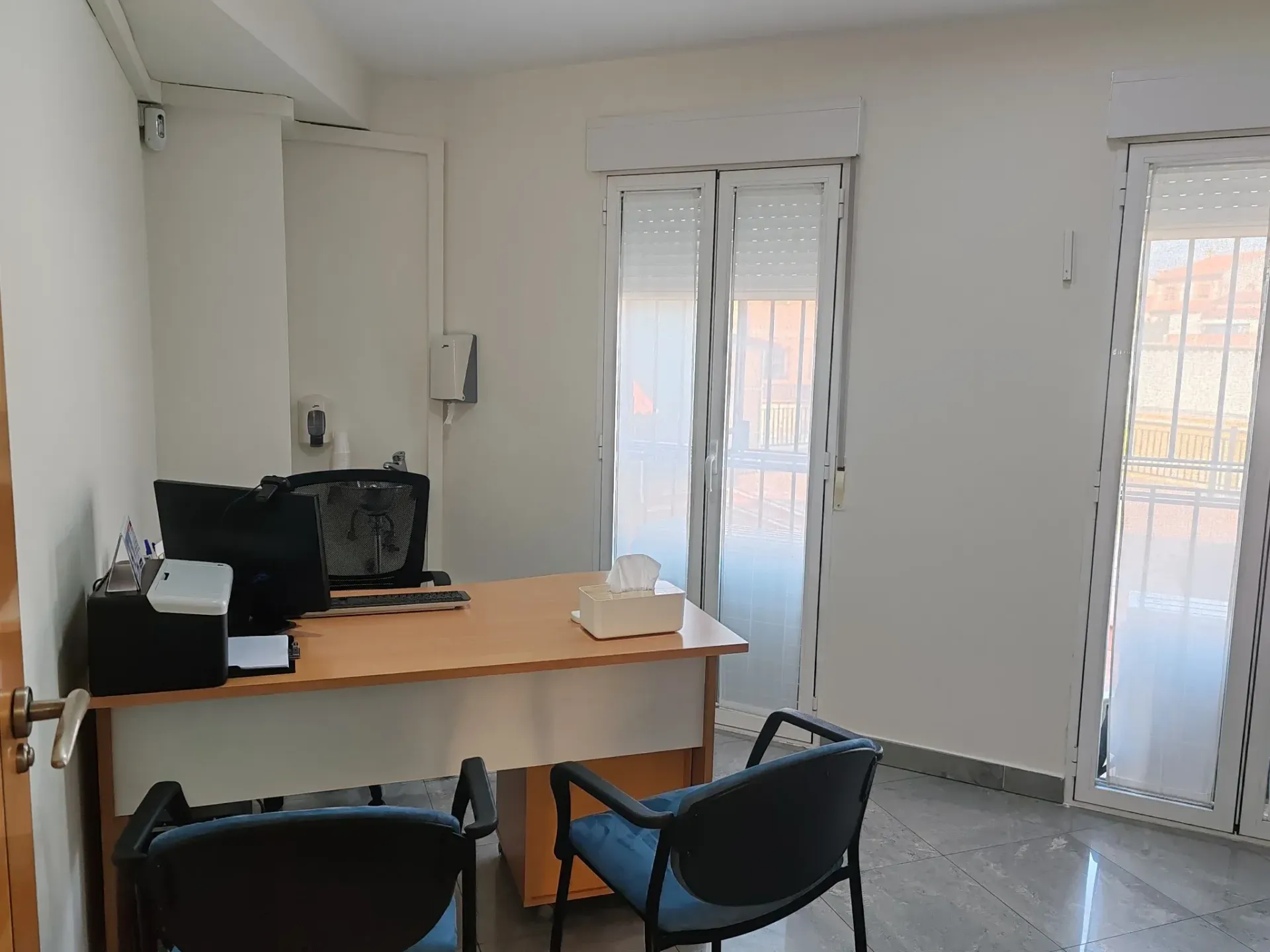 Un consultorio médico con un escritorio y sillas