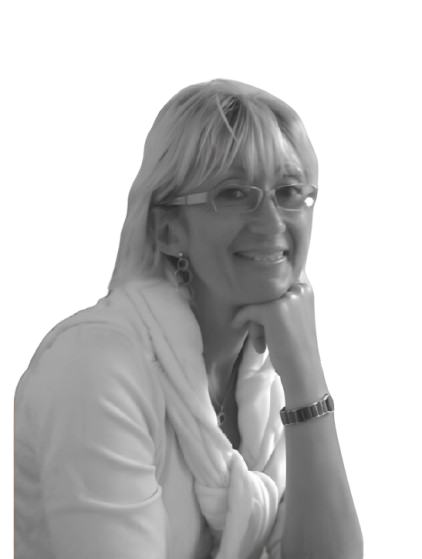 Femme à lunettes, souriante, le menton appuyé sur la main.