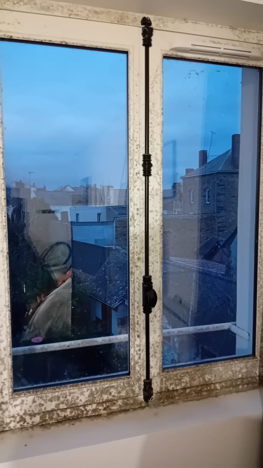 Une fenêtre avec vue sur une ville et des bâtiments.