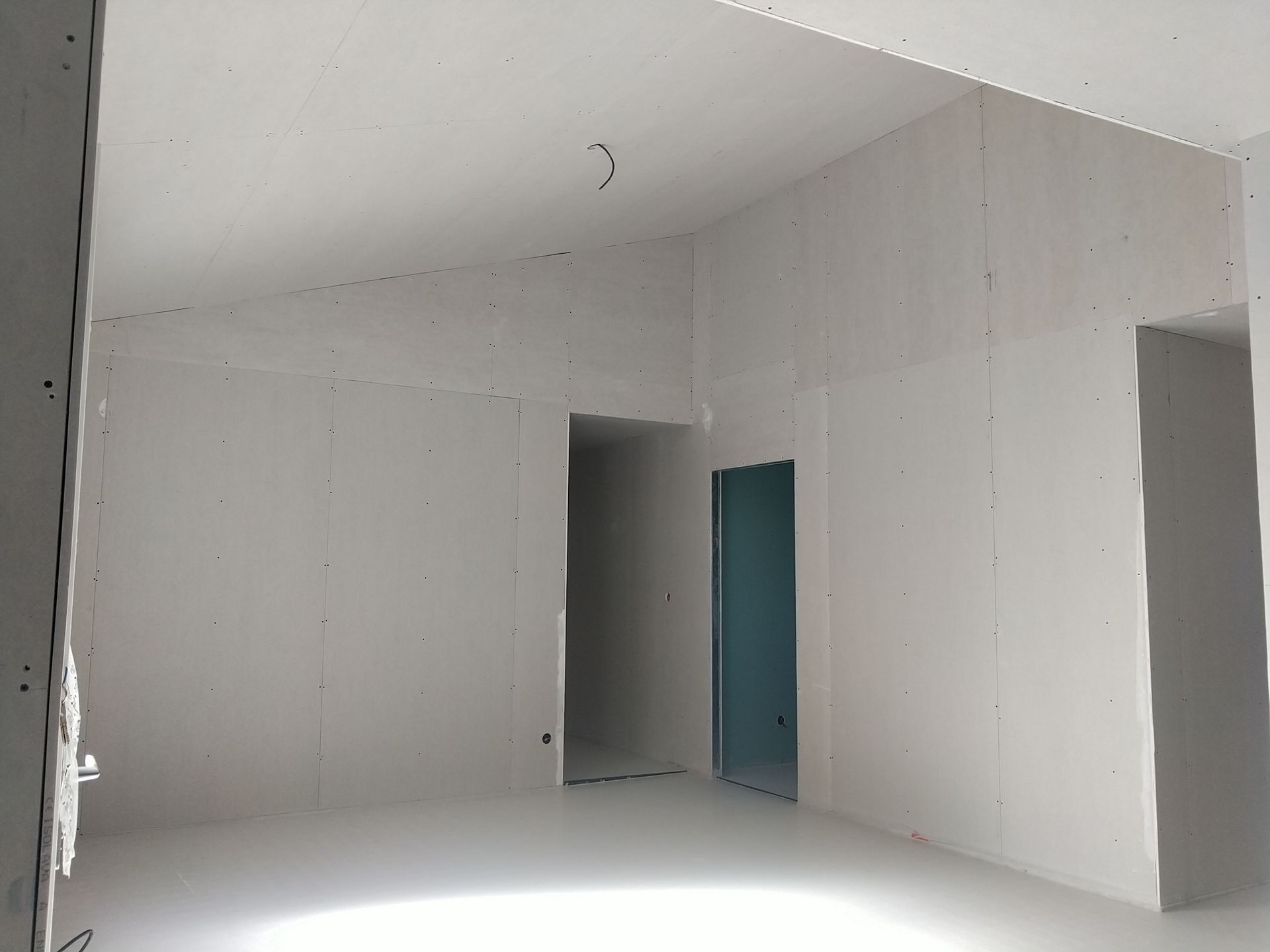 Trois espaces de porte ouverts dans une pièce en travaux