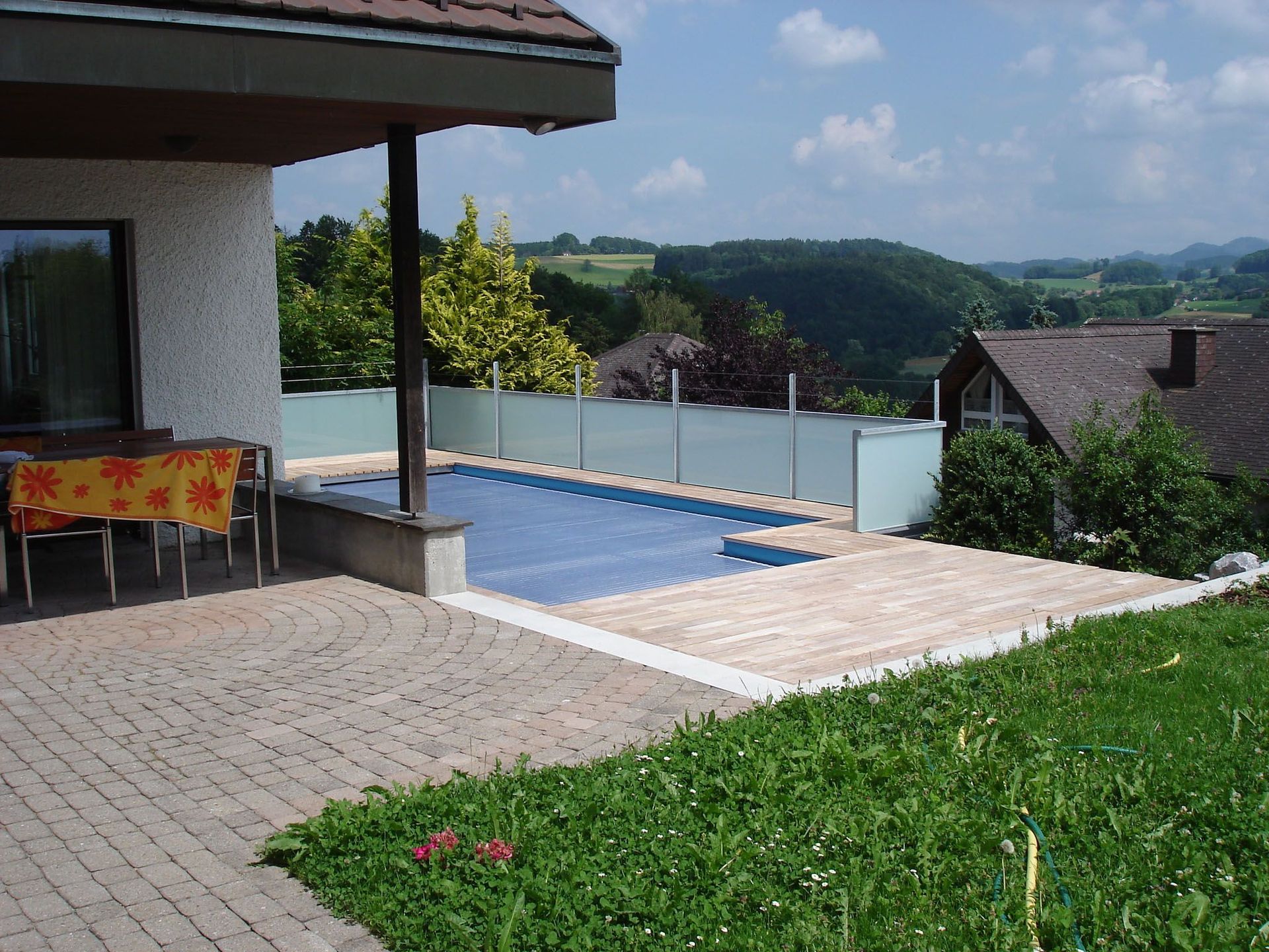 Eine Terrasse mit einem Swimmingpool im Hintergrund