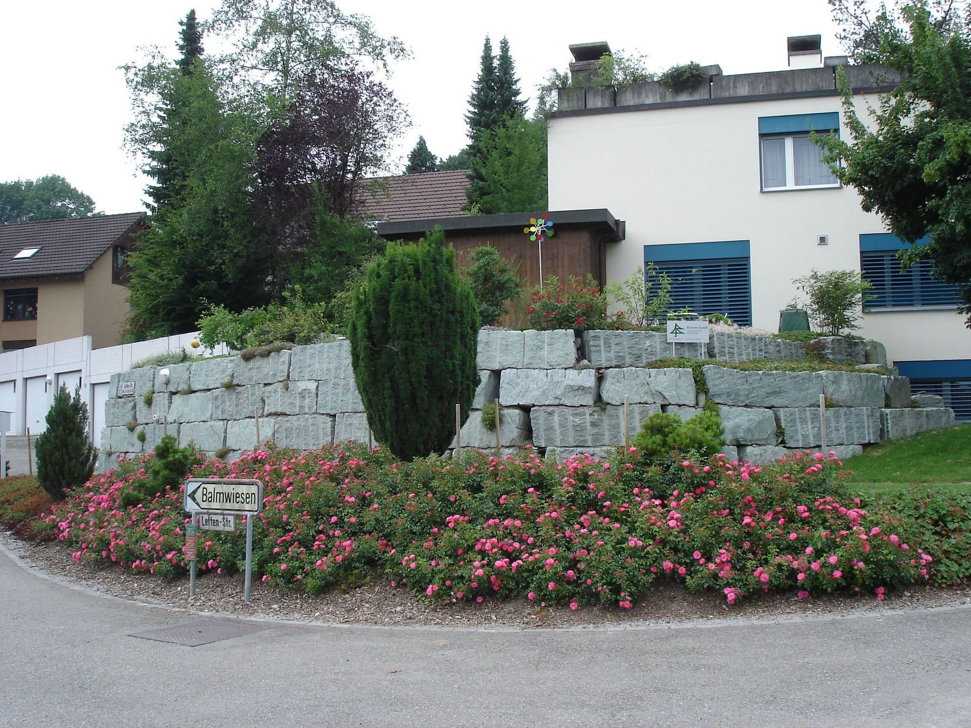Ein Haus mit einer Steinmauer und Blumen davor