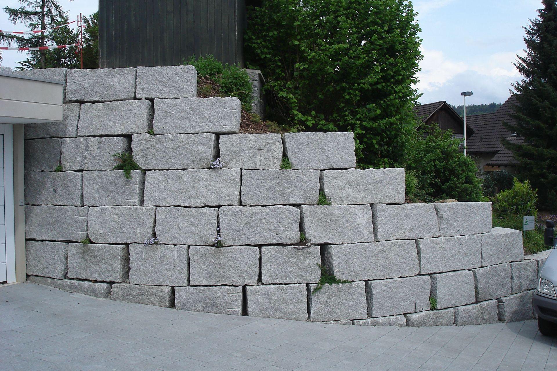 Eine große Steinmauer mit einem davor geparkten Auto