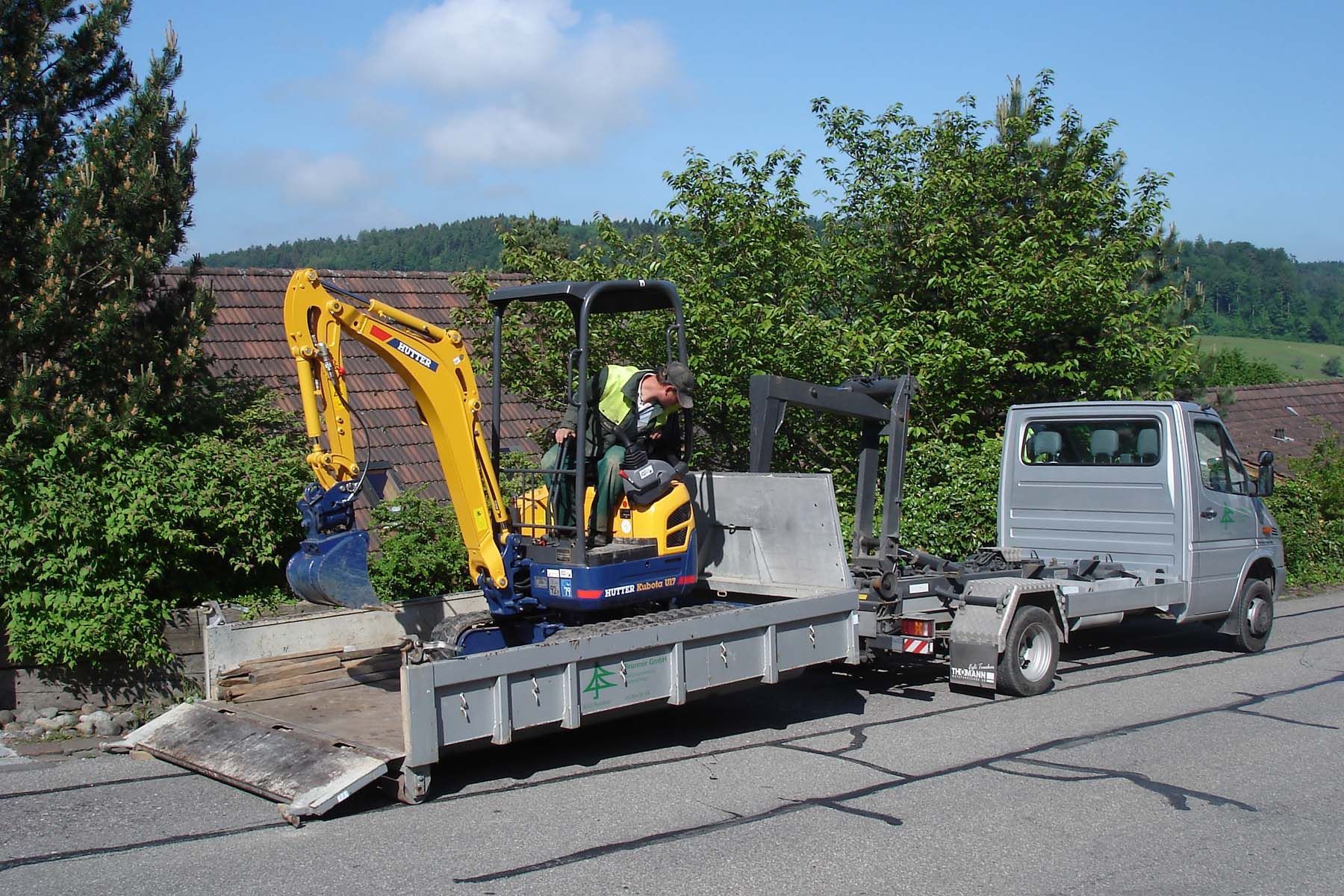 Ein gelber Bagger wird von einem LKW gezogen
