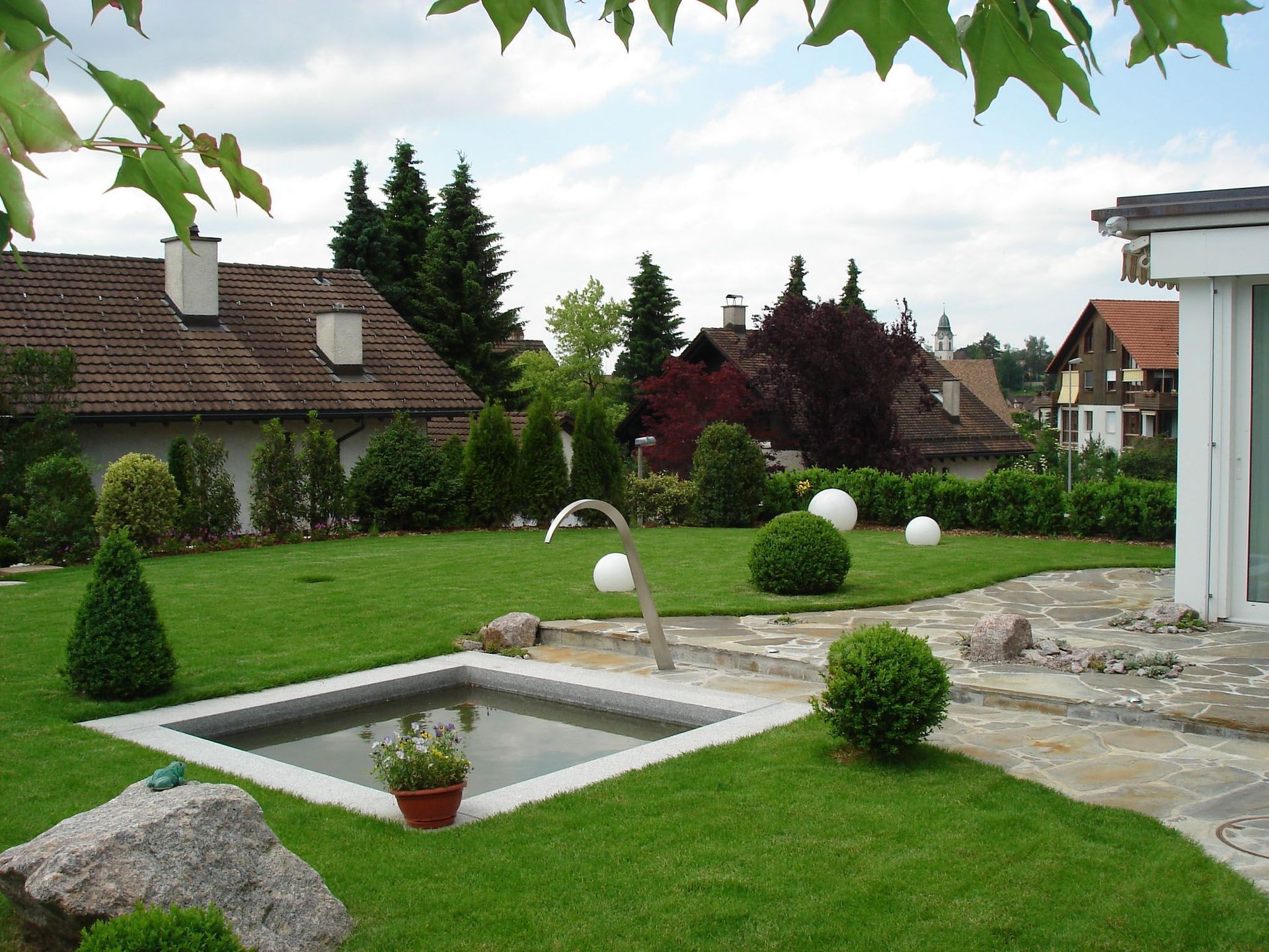 Ein üppiger grüner Garten mit einem kleinen Teich in der Mitte