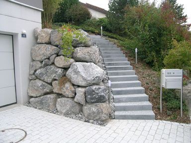 Eine Treppe, die zu einer Garage neben einer Steinmauer führt