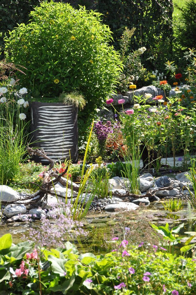 In der Mitte eines Gartens befindet sich eine kleine Brücke über einem Teich.