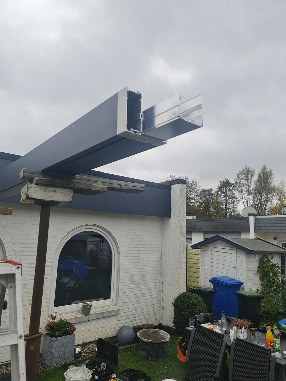 Ein großes Stück Metall hängt vom Dach eines Hauses.