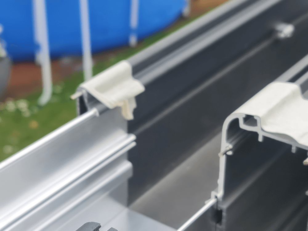 Eine Nahaufnahme von einem Stück Metall mit einem blauen Pool im Hintergrund